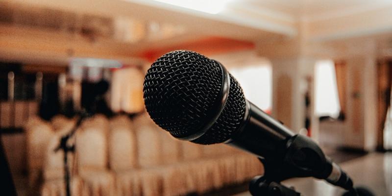 Photo of a microphone, lecture hall on a background.