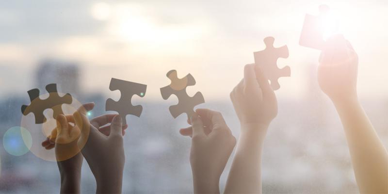 Illustrative picture of hands holding puzzle pieces