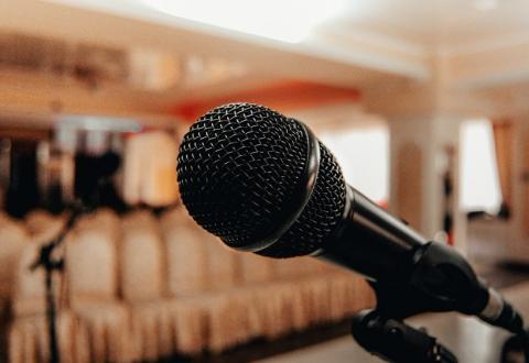 Photo of a microphone, lecture hall on a background.