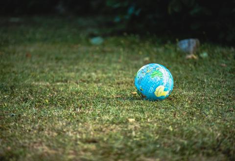 Maapallokuvioinen pallo nurmikolla.